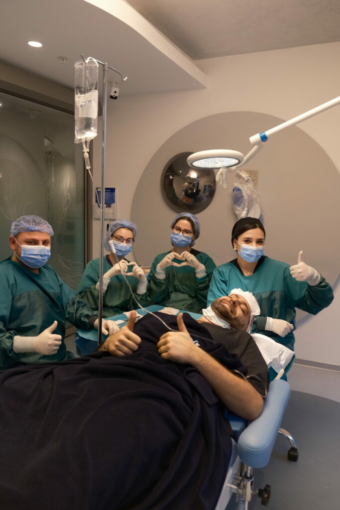 مريض داخل غرفة زراعة الشعر برفقة الفريق الطبي في أجواء احترافية ومريحة أثناء إجراء العملية داخل عيادة إليت هير