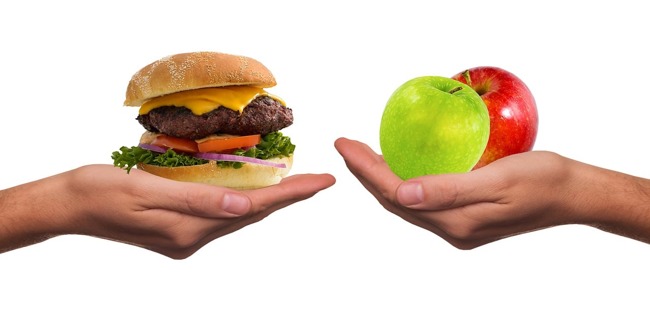 Ursachen von Haarausfall - Apfel und Burger in der Hand