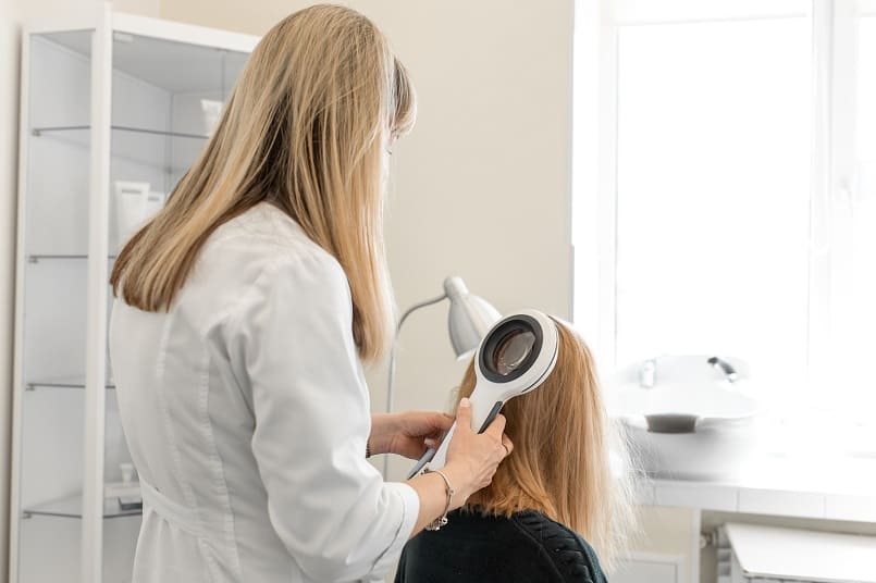 Dermatologin prüft den Status der Haare bei einer Patientin