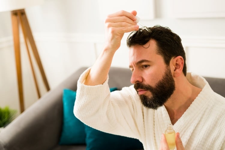 Mann wendet Haaröl für die Haare gegen 
Haarausfall an