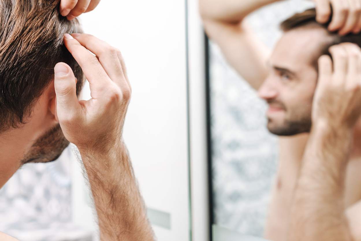 Hombre mirándose en el espejo preocupado