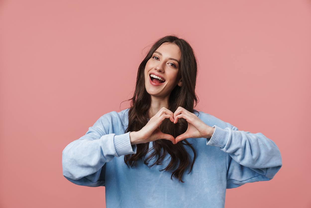 Mujer haciendo la forma de un corazón con las manos