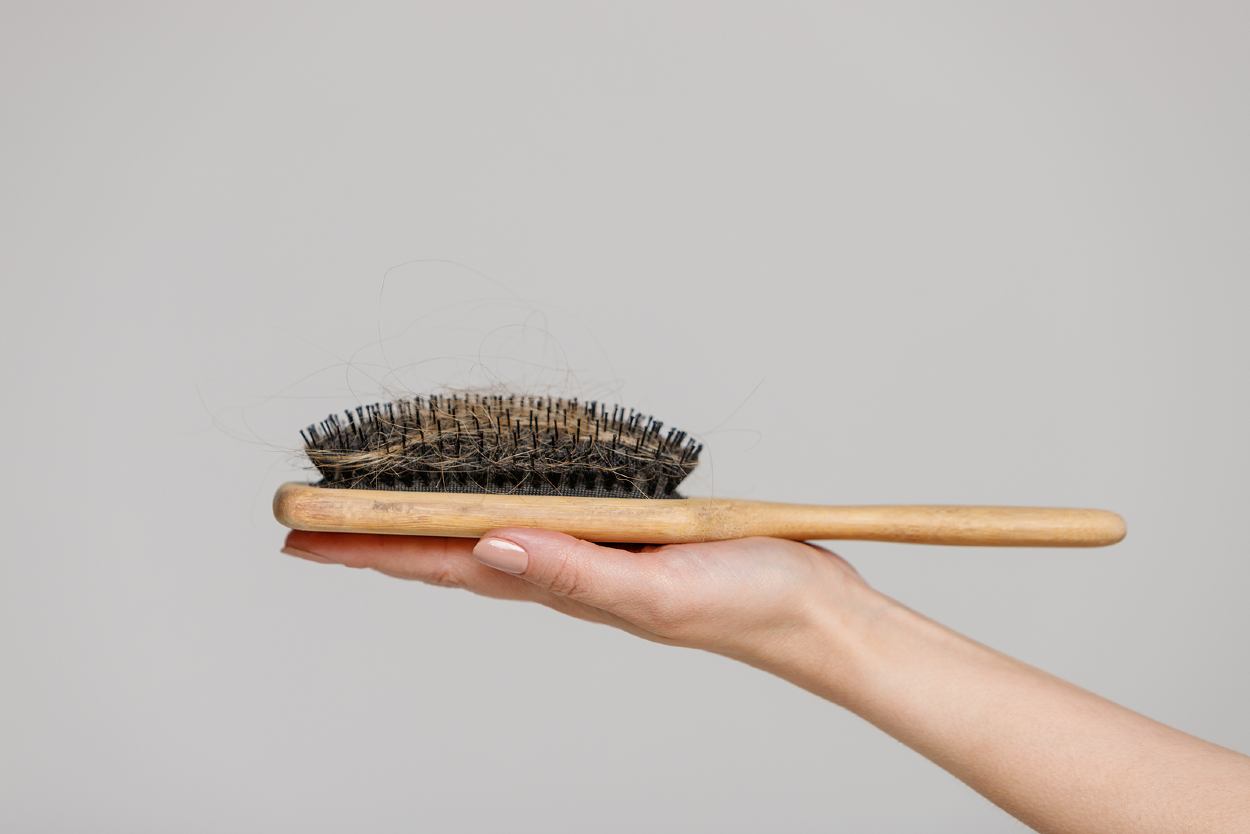 Mujer sosteniendo un cepillo con pelos sueltos