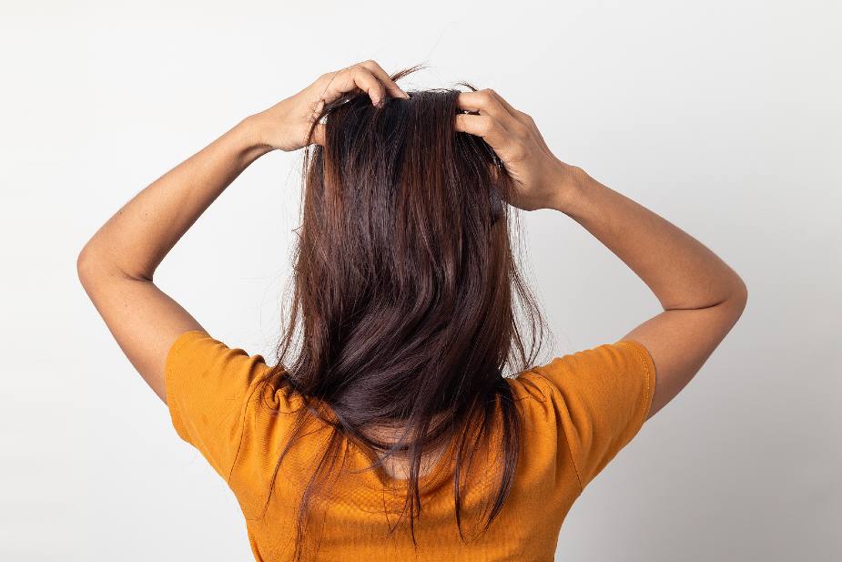 Mujer levantando las raíces del cabello con los dedos