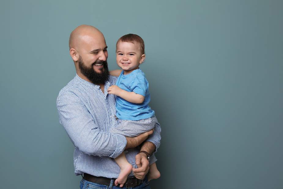 Genes Hombre calvo sosteniendo a su bebé en brazos. La calvicie genética puede ser hereditaria