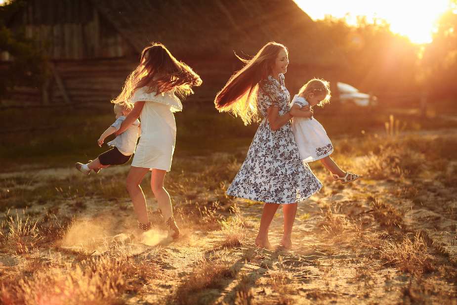 Felicidad Mujeres jugando con niños al atardecer al aire libre