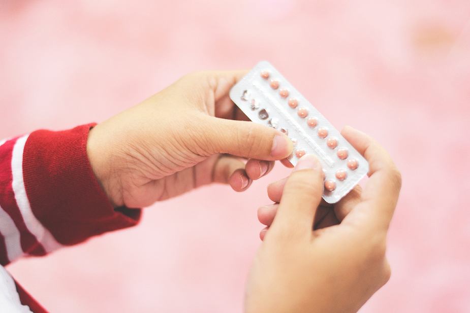 Mujer sujetando un blíster con píldoras anticonceptivas