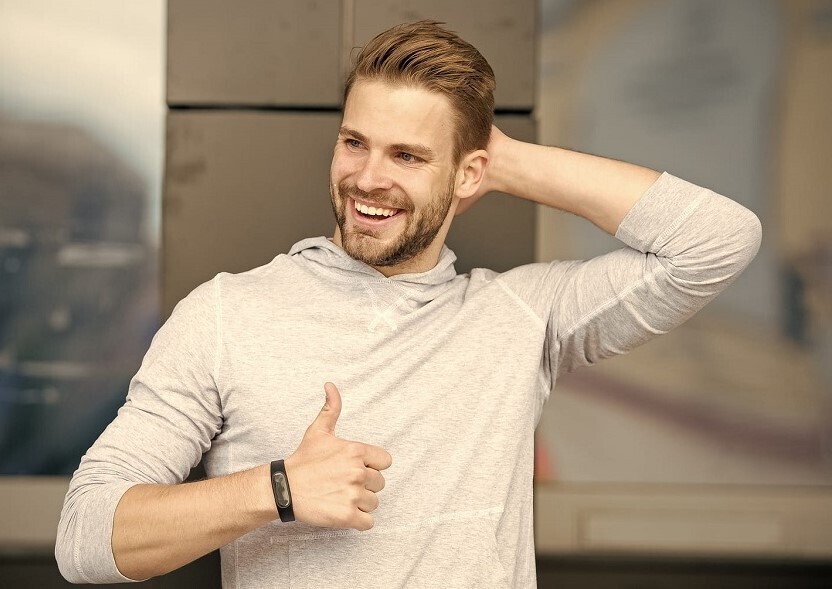 Hombre feliz con dedo hacia arriba al saber su edad para injerto capilar
