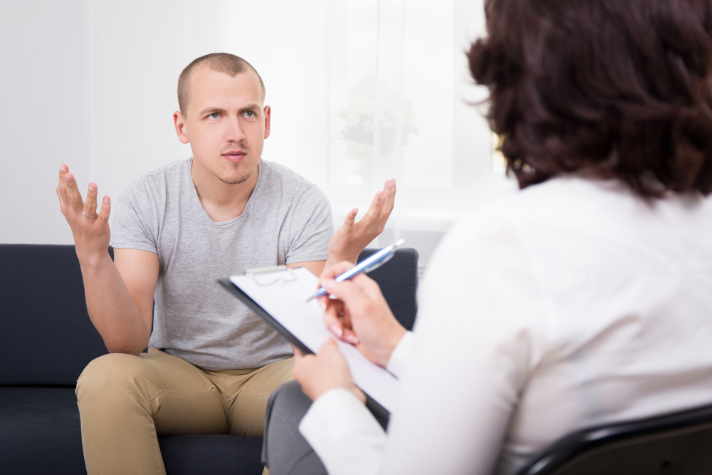 spécialiste des cheveux posant des questions à un patient lors d'une consultation au sujet de sa calvitie