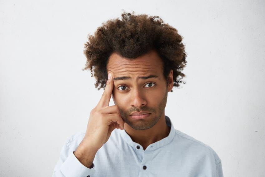 homme avec cheveux afro s'inquiéte de sa calvitie naissant sur l'avant de sa tête