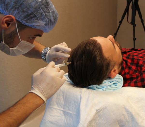 Un patient recoit une injection de plasma riche en plaquettes ou traitement PRP à la clinique Elithair