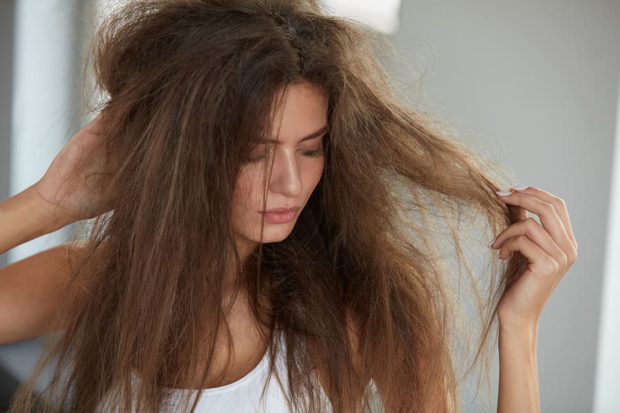 foto di una donna con capelli secchi e crespi