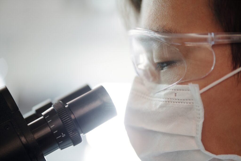 Doctor using a microscope to analyse micrografting mixture