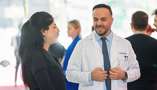 Dr. Moustafa with Elithair team member smiling having a conversation
