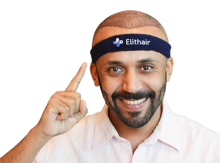 A smiling man pointing upward with his finger, wearing an Elithair headband shortly after a successful hair transplant