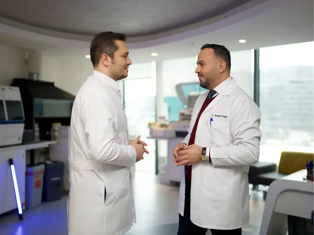 Two doctors in white coats discussing treatment in a modern medical clinic