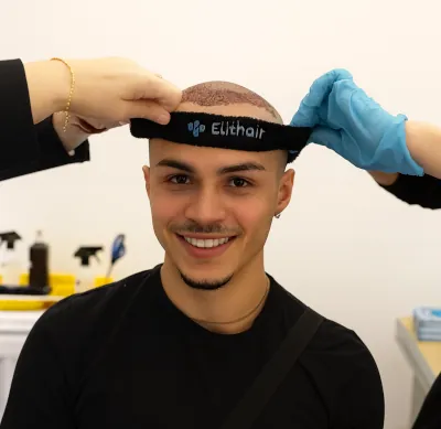 Paciente sonriente al que se le coloca la cinta tras el trasplante de cabello en Turquía